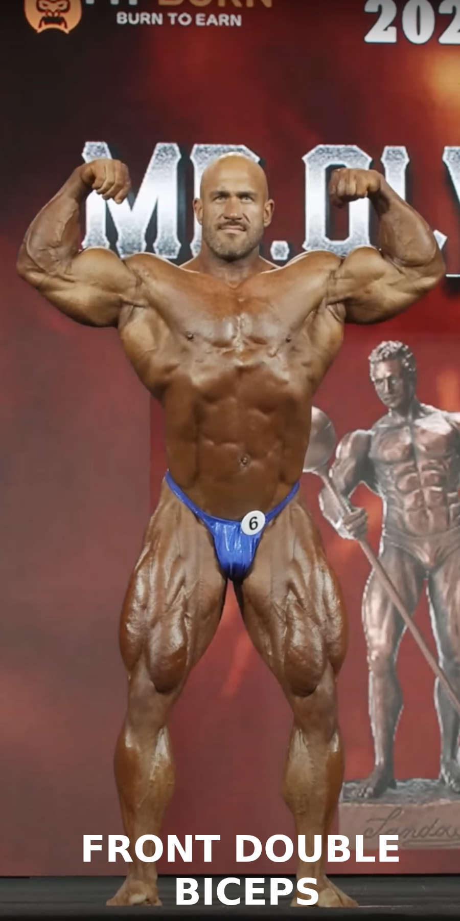 A bodybuilder performing the front double biceps pose on stage during a bodybuilding competition 