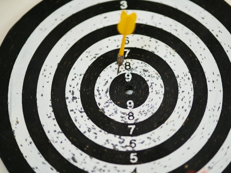 A bulls eye with a dart near the center, resembling the importance of precise goal setting.
